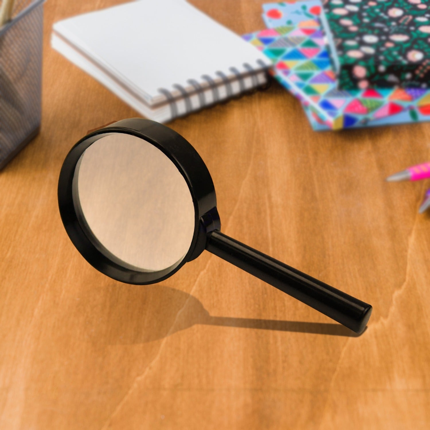 Breakage-proof magnifying glass for reading with a sturdy handle on a wooden desk