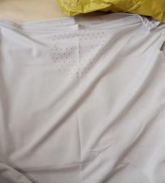 Close-up of a breathable neck length mouth mask fabric showing ventilation holes for improved airflow