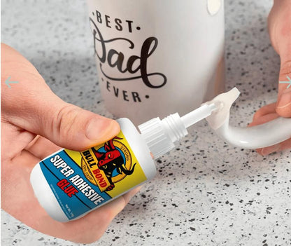 Person applying strong bonding glue for home use from small bottle to repair broken mug handle on countertop