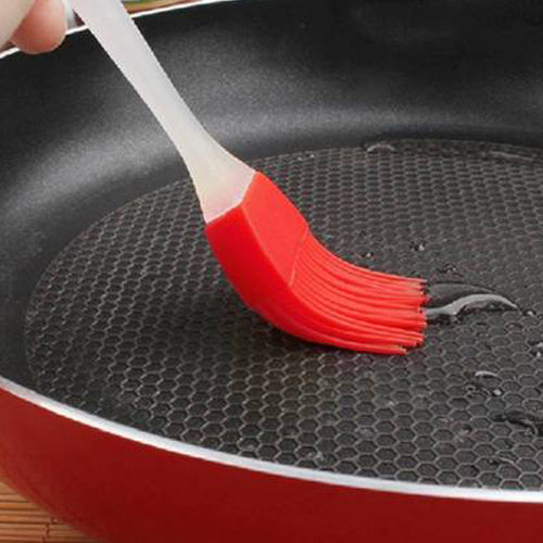 Your Brand cake decorating spatula and pastry brush set in use for greasing a frying pan