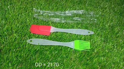 Cake decorating spatula and pastry brush set in red and green on grass background