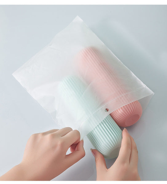 Two capsule bottle portable storage containers in pink and blue with a transparent storage bag