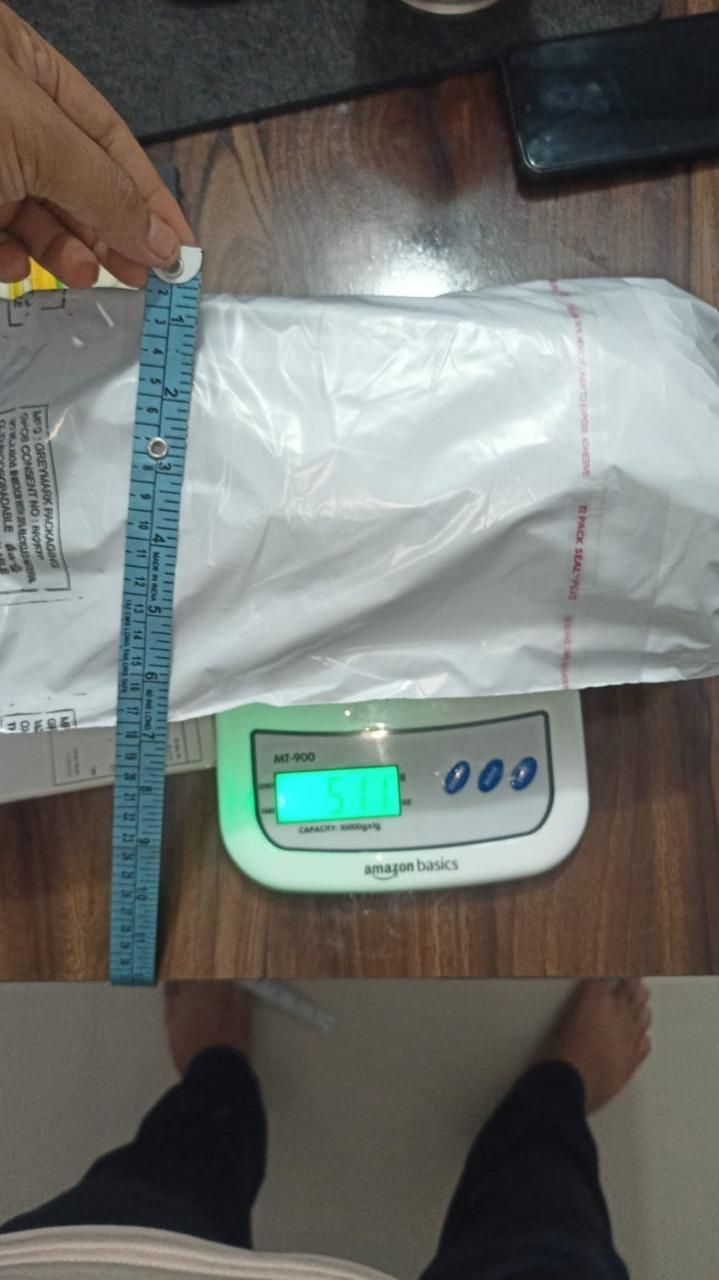 Packaging of a car fire extinguisher spray being measured with a ruler on a digital scale