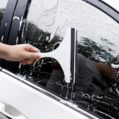 Car mirror wiper being used to clean a car window with soap and water for a clear view