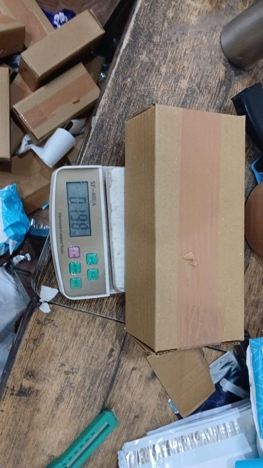Brown cardboard box for car seat gap filler on a wooden surface with a digital scale