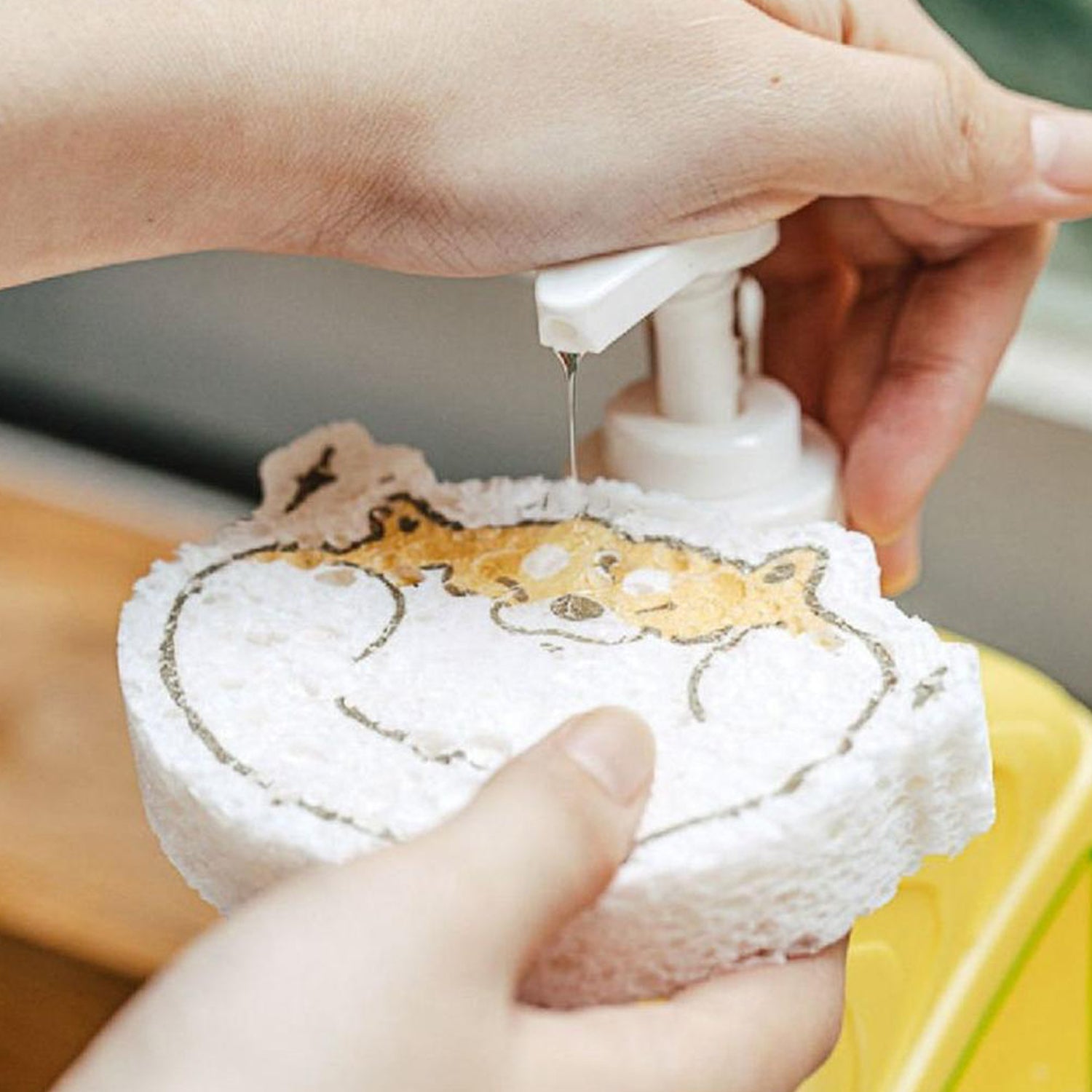 Using a cartoon wood pulp dish sponge for cleaning dishes with soap dispenser