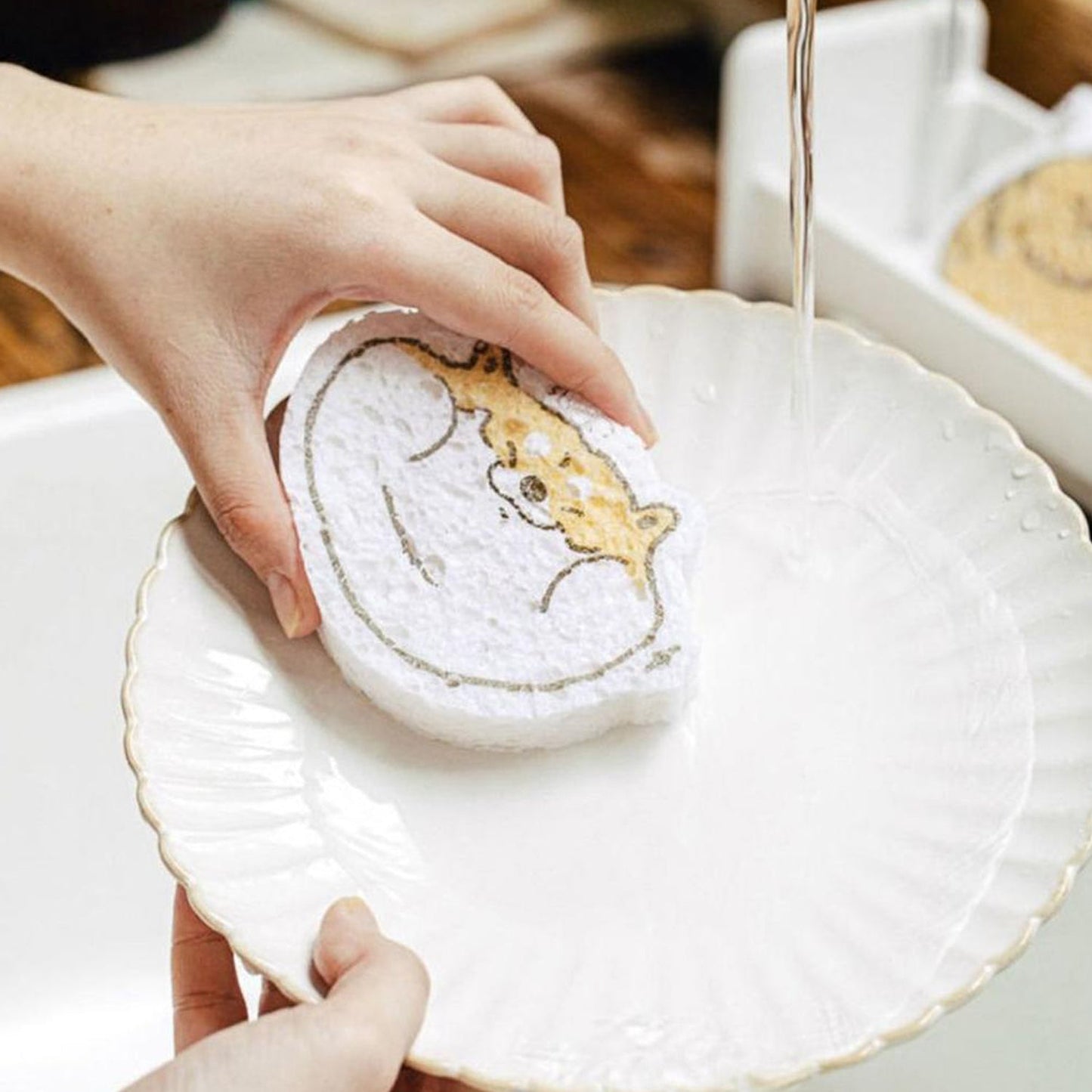 Cartoon wood pulp dish sponge being rinsed in a sink, perfect for cleaning dishes effortlessly