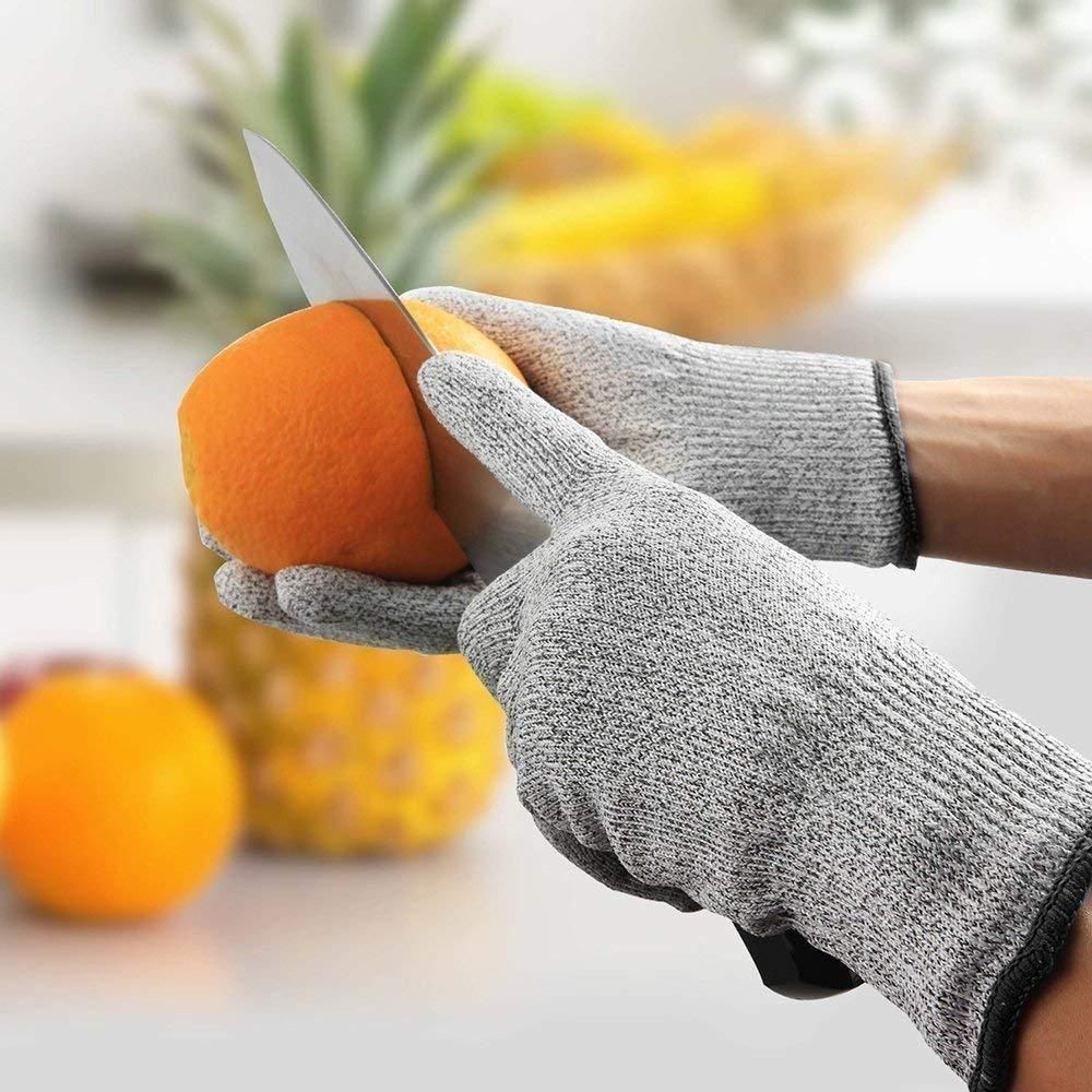 Cut resistant gloves slicing an orange with a kitchen knife product shot for wooden chopping board with knife set