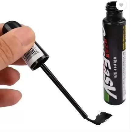 Car paint scratch remover in a black applicator bottle with a brush for easy usage