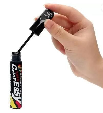 Hand holding Color Easy car paint scratch remover bottle with applicator for touch-up repairs