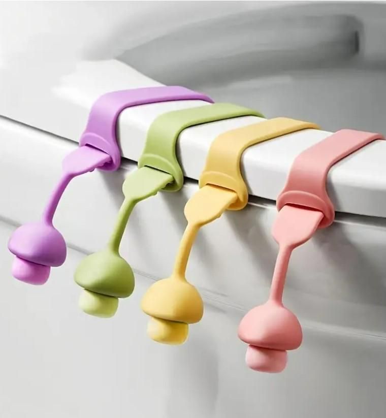 Set of colorful hygienic toilet lid lifter hooks hanging on a white toilet seat edge