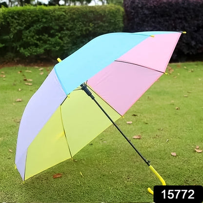 colorful rainbow umbrella with pastel blue pink yellow and purple panels on grass