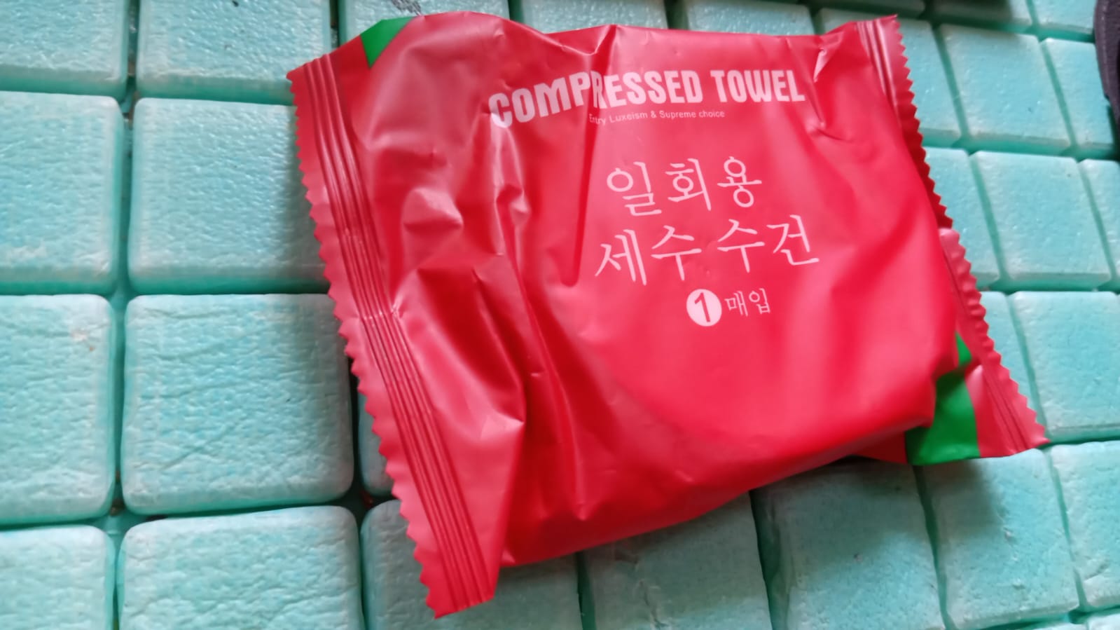 Compressed cotton towels for travel in a red package, perfect for convenient packing