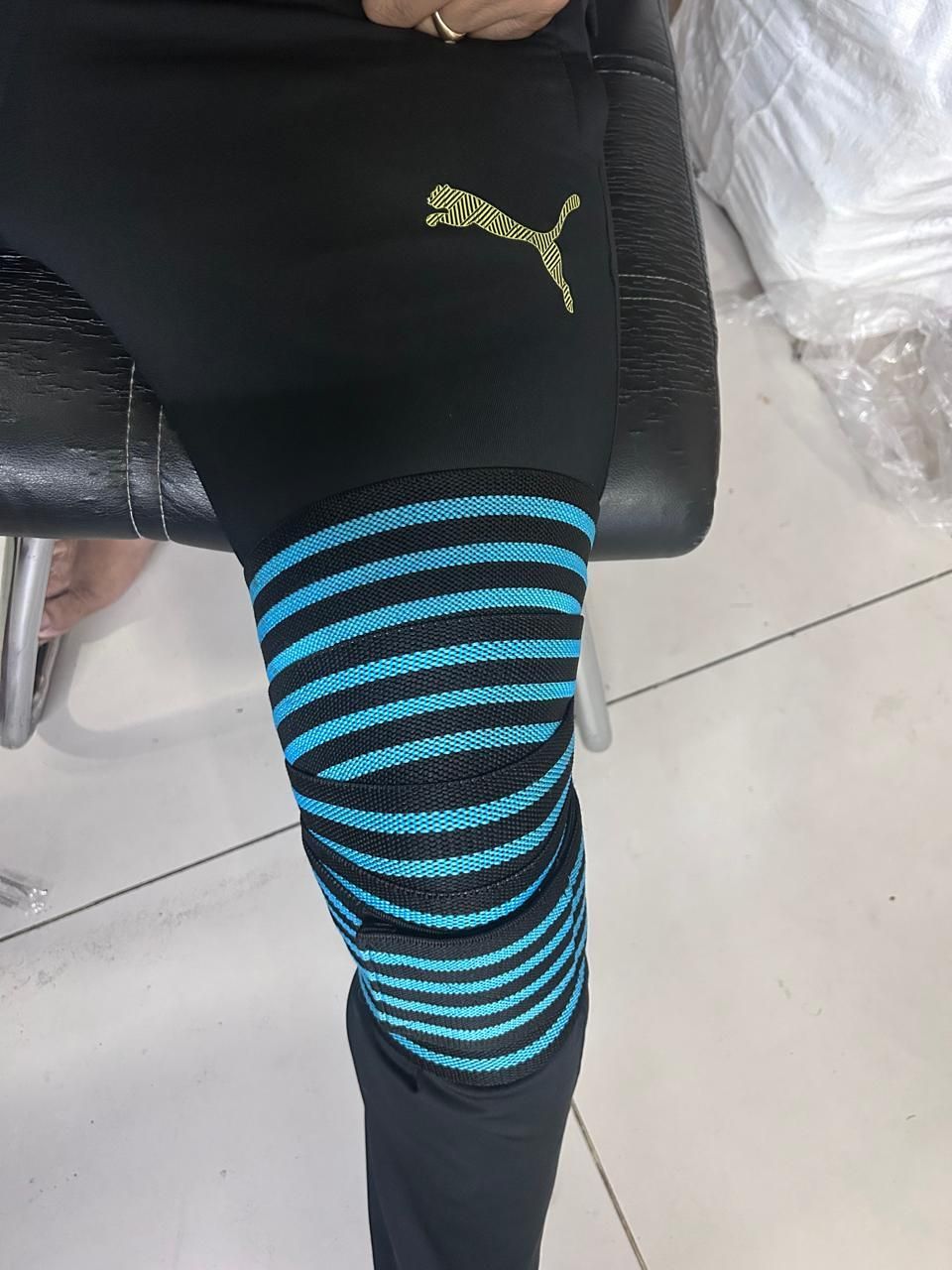 Puma compression knee wraps for support featuring black and blue striped design for optimal stability