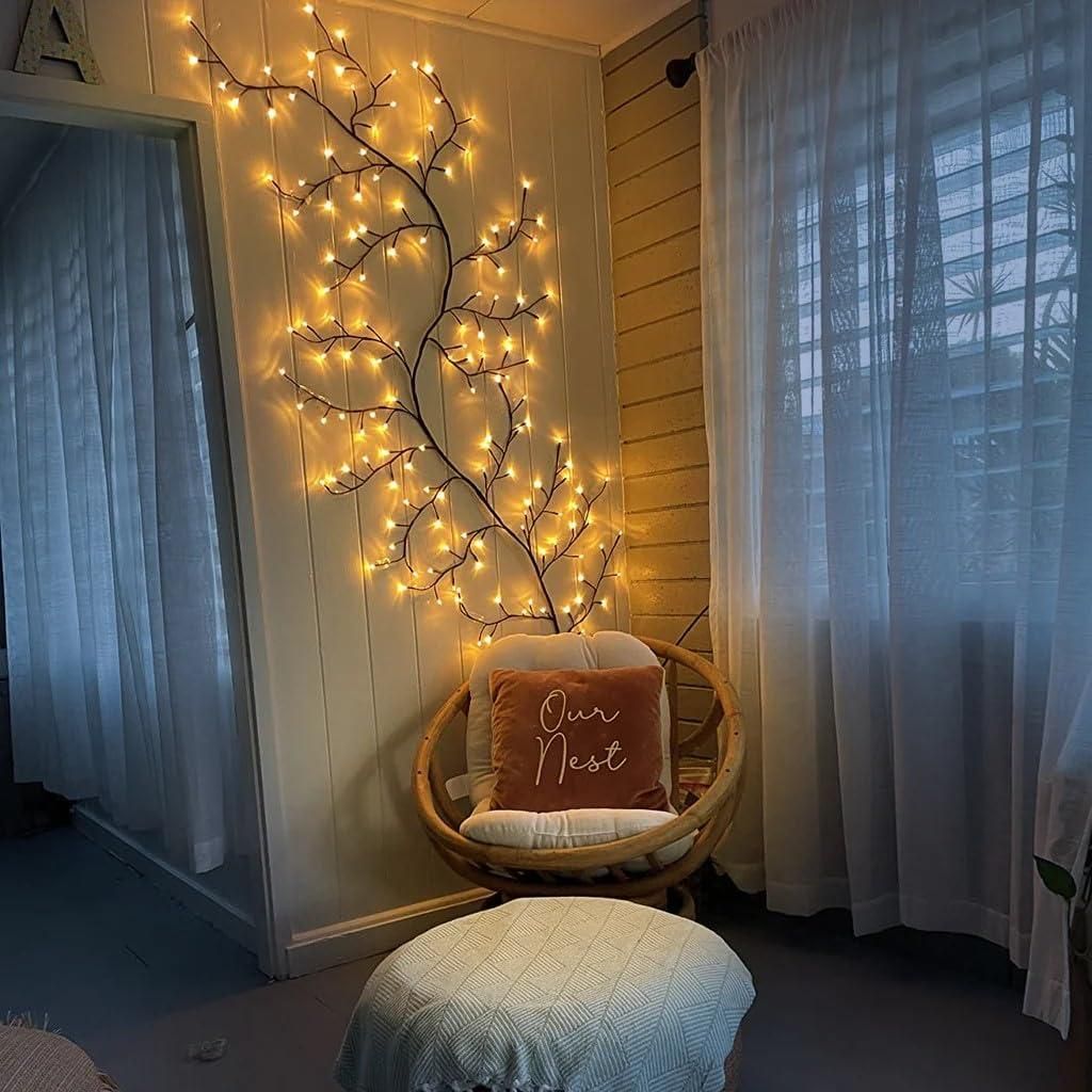 Decorative branch fairy lights illuminating a cozy room with a rattan chair and soft cushions
