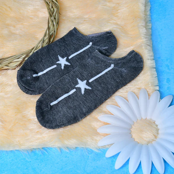 Gray designer socks for women featuring star patterns on a soft surface