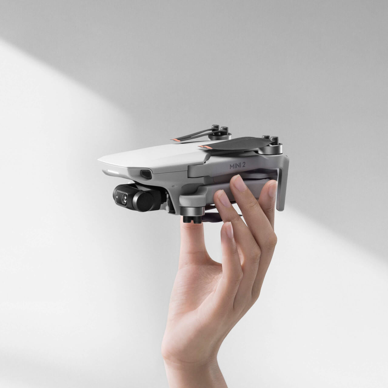 Hand holding DJI Mini SE drone combo showcasing compact design and advanced features