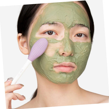 Woman applying green face mask using a double-headed silicone mask brush for even coverage