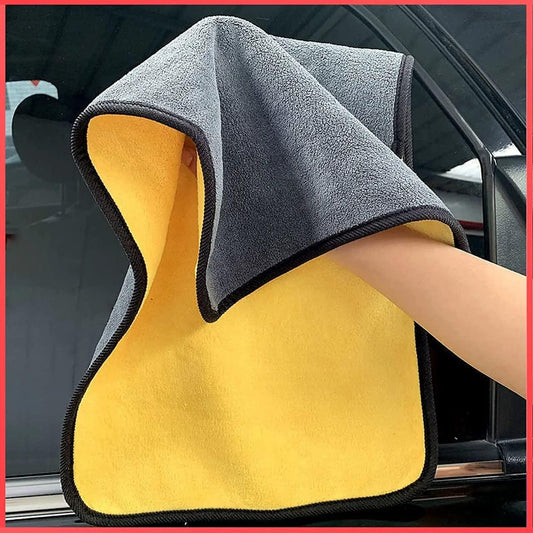 Hand using double sided automotive cleaning towels on a car window for effective cleaning