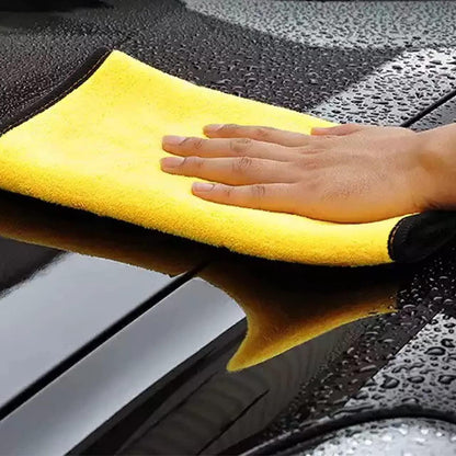 Yellow double sided automotive cleaning towels being used to wipe a wet car surface