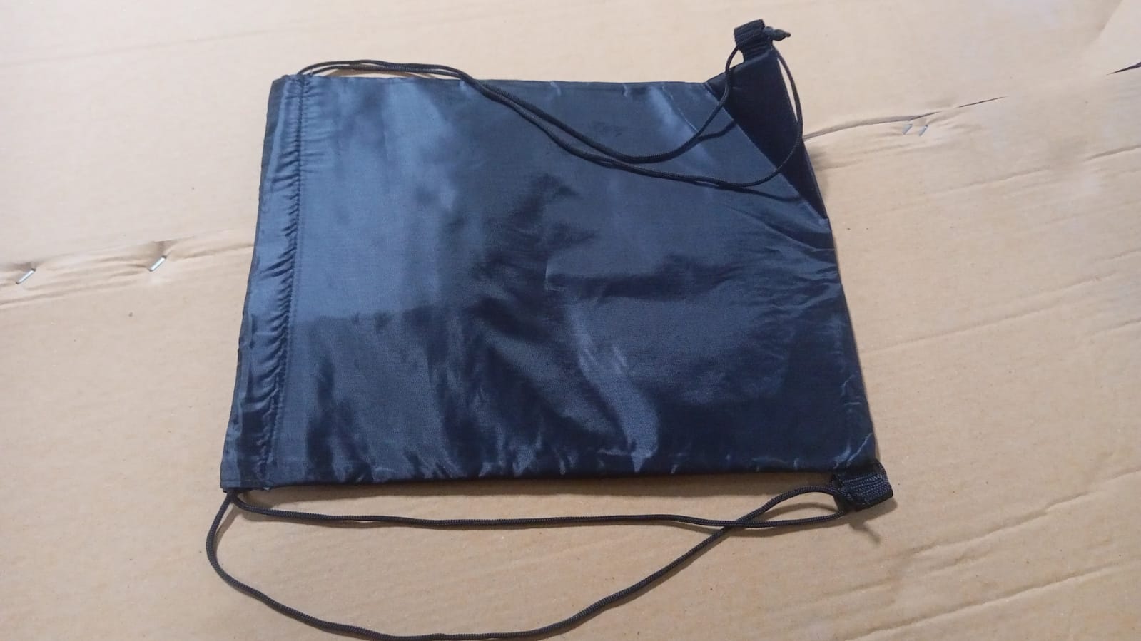Black drawstring sport bag for gym made of durable material, perfect for carrying workout essentials