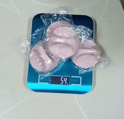 Three pink adhesive handles for cabinets wrapped in plastic on a digital scale showing 54 g