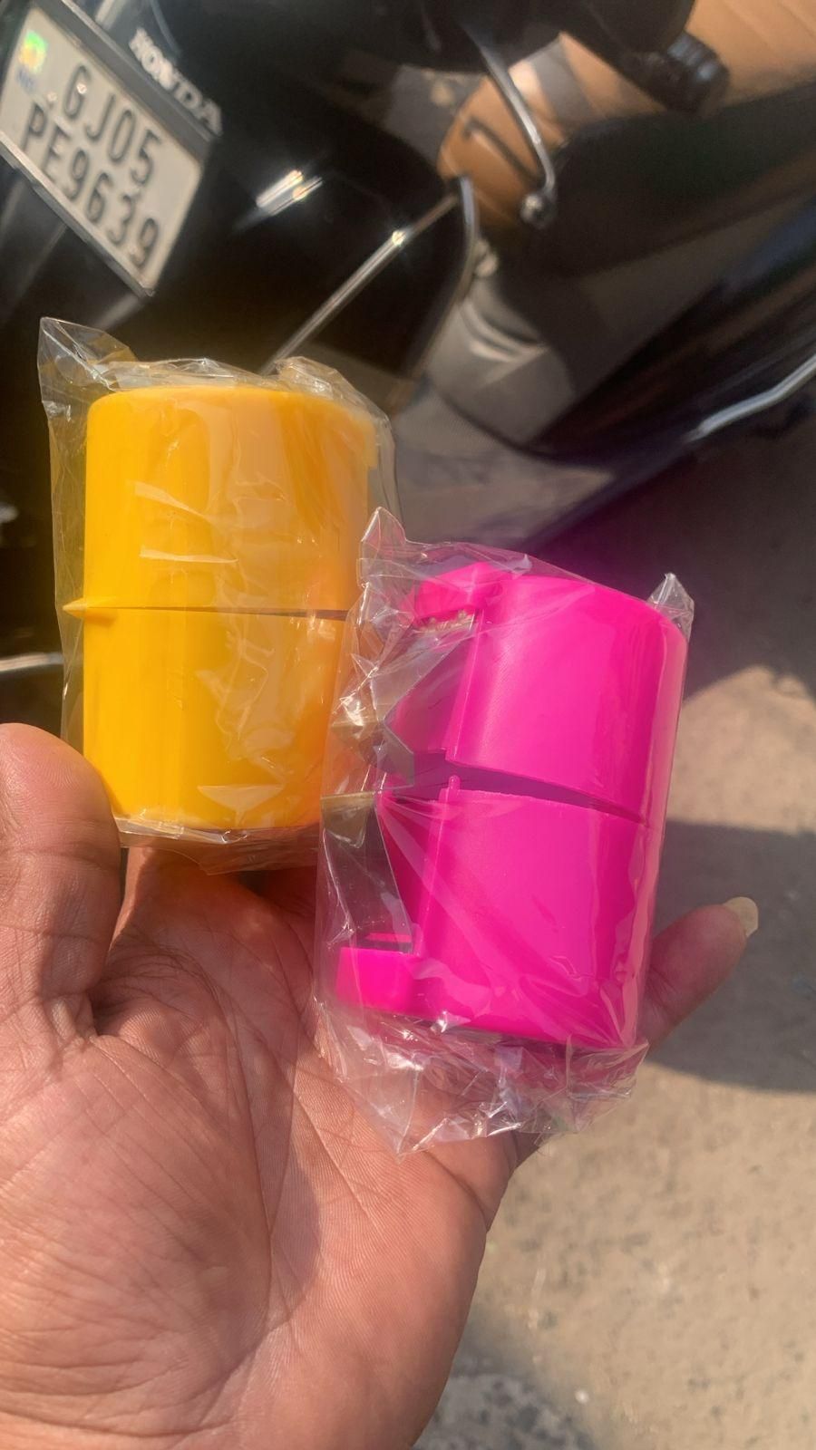 Yellow and pink egg topper cutter tool in hand wrapped in clear plastic packaging