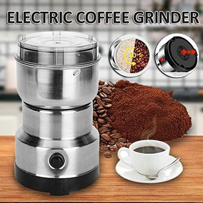 Electric portable coffee bean grinder in stainless steel with ground coffee and cup of coffee