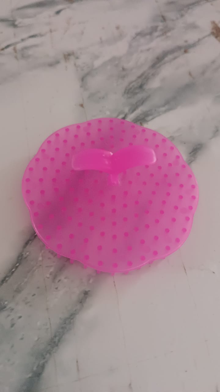 Pink ergonomic scalp massager brush with textured surface for a relaxing head massage