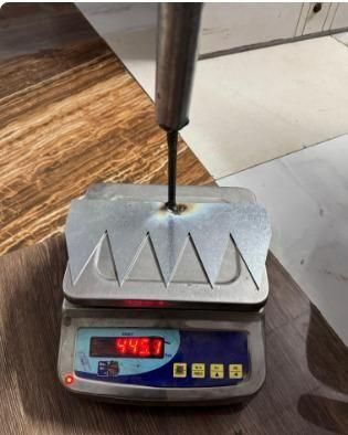 The Gir Farmer heavy duty metal garden weed remover with serrated blade on digital scale showing 443 g