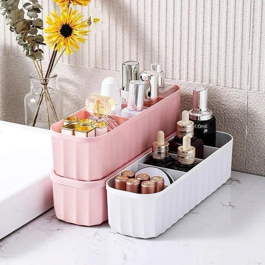 Pink and white drawer organizers for makeup holding lipsticks and bottles on marble countertop