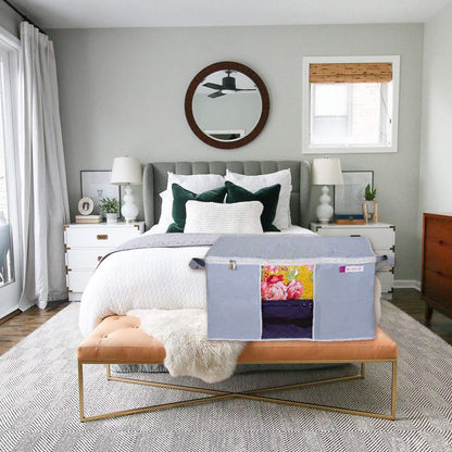 Large capacity storage bags for bedding in gray fabric placed on bedroom bench with floral bedding inside