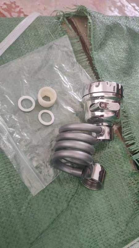 Chrome sink sprayer attachment for kitchen faucet with washers and plastic adapter on green cloth