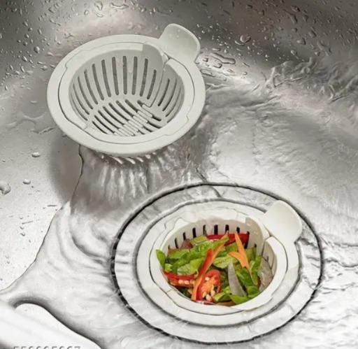 White sink strainer for food particles in kitchen sink catching vegetable scraps and debris