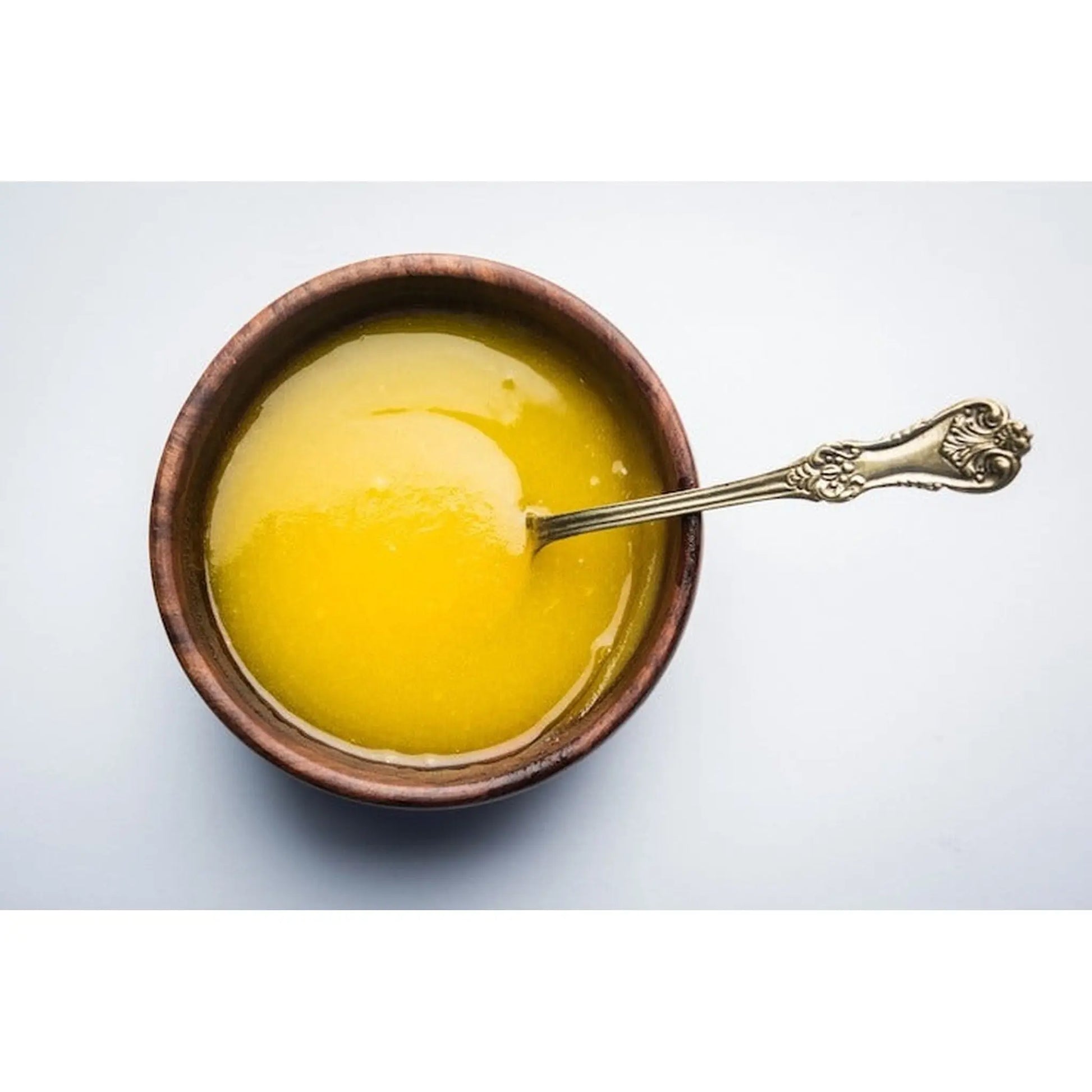 Smooth golden ghee from A2 milk in a wooden bowl, perfect for cooking and adding flavor
