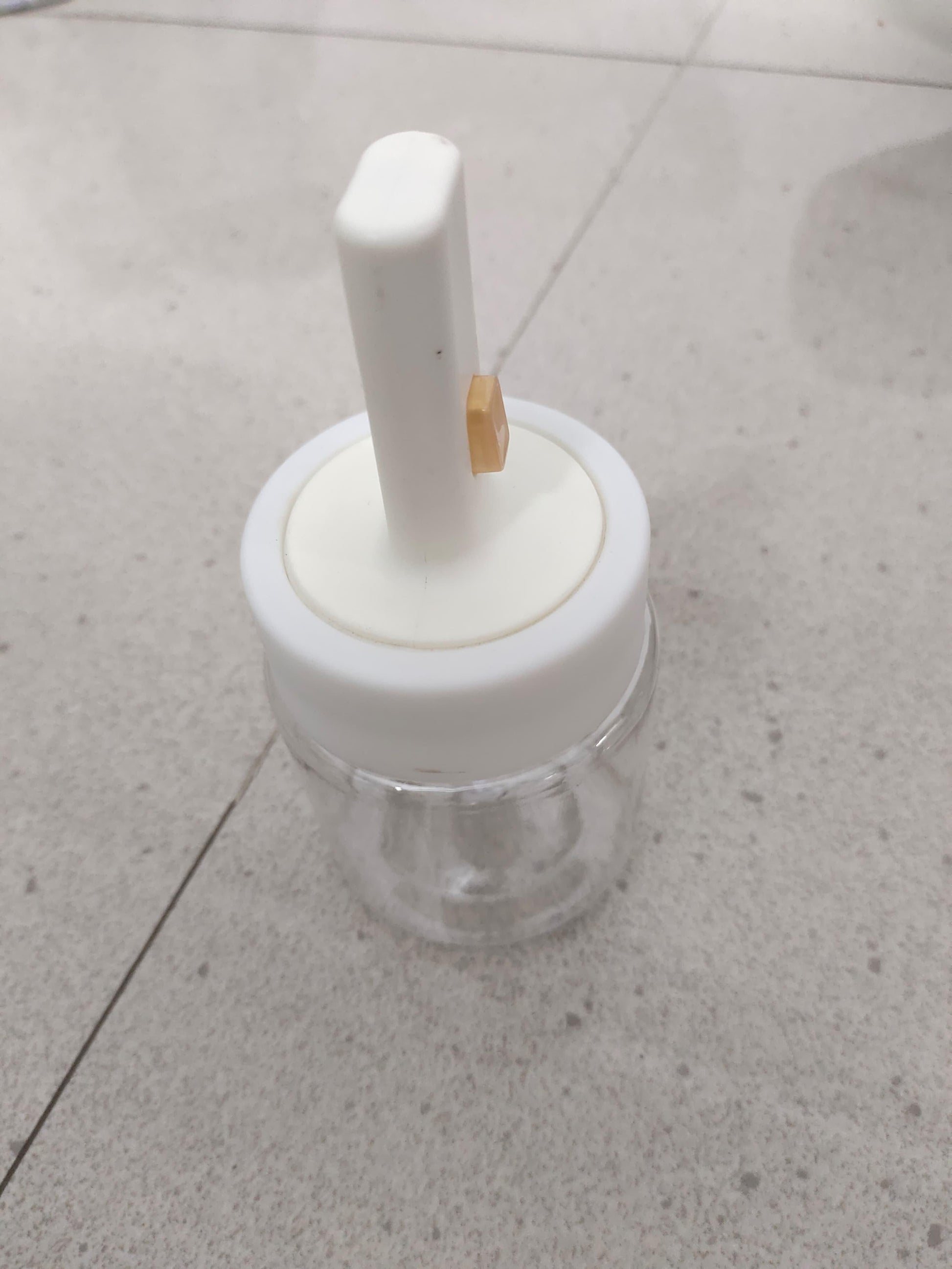 Clear glass seasoning jar with spoon lid and white plastic top for easy spice storage