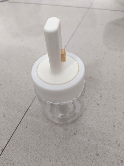 Clear glass seasoning jar with spoon lid and white plastic top for easy spice storage