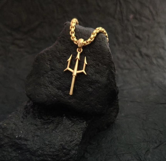 Gold Plated Trishul Pendant on a chain displayed on a textured black surface