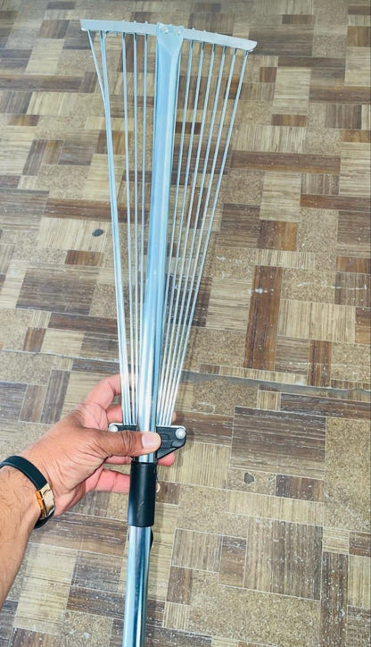 Hand holding adjustable metal leaf rake from THE GIR FARMER, the best tool for cleaning garden leaves