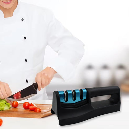 Professional chef using a handheld kitchen knife sharpener on a chef's knife while preparing vegetables