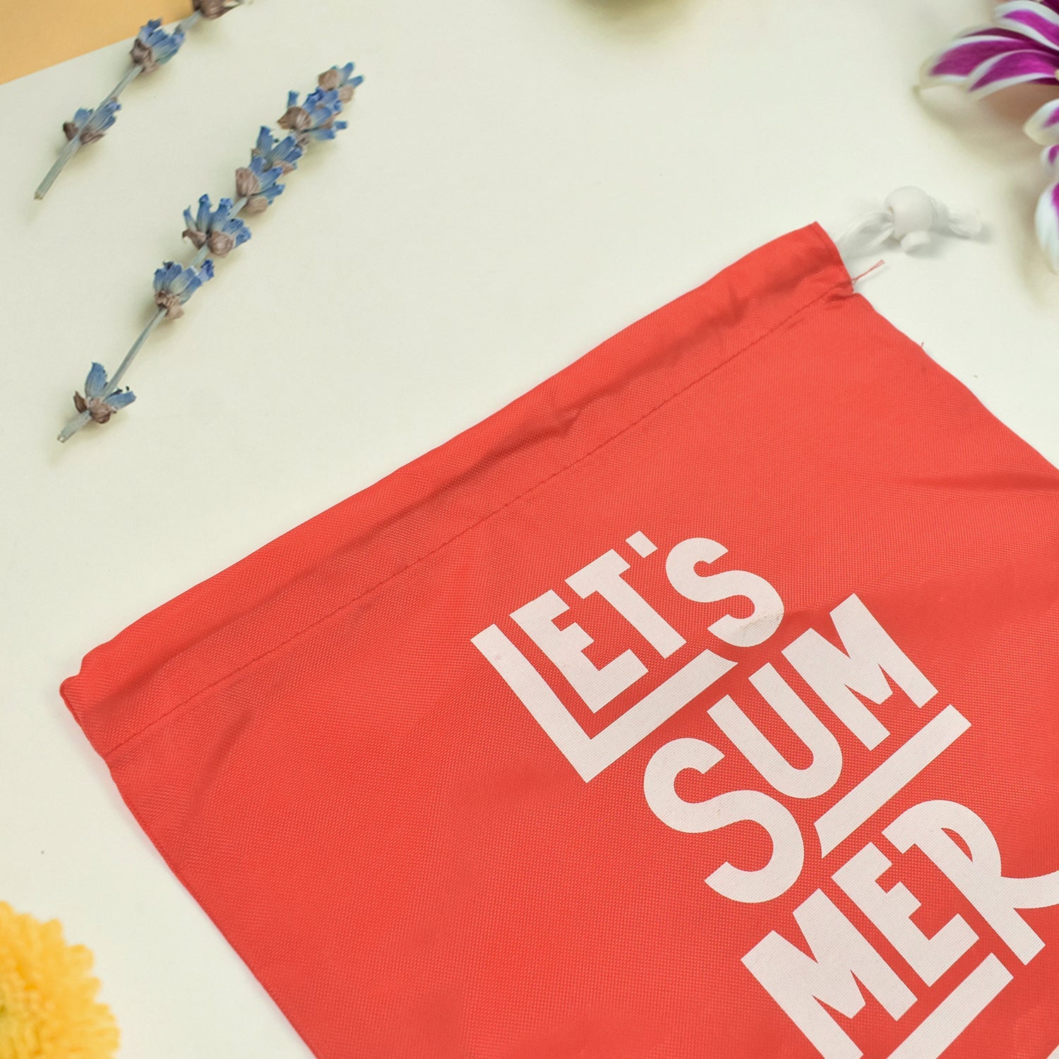 Heavy duty drawstring bag in red with playful text 'Let's Summer' for durable storage and travel