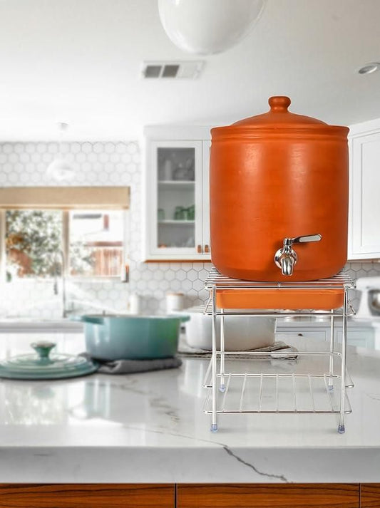 Heavy steel matka stand supporting a clay water container in a modern kitchen setting