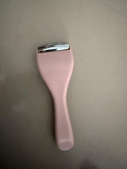 Pink ice roller for face with a smooth metal head for reducing puffiness and soothing skin