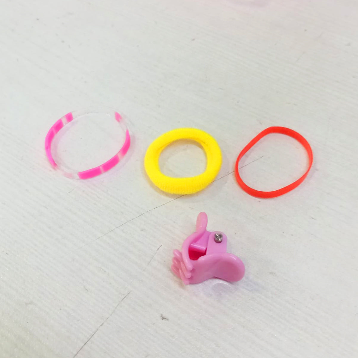 Cute round hair accessories for girls including colorful hair ties and a pink hair clip by Amd-Deodap