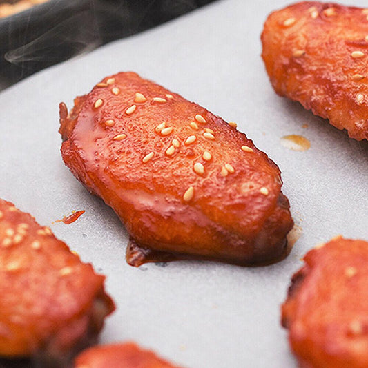 Glazed sesame chicken wings on Your Brand microwave oven safe baking paper showing steam and nonstick surface