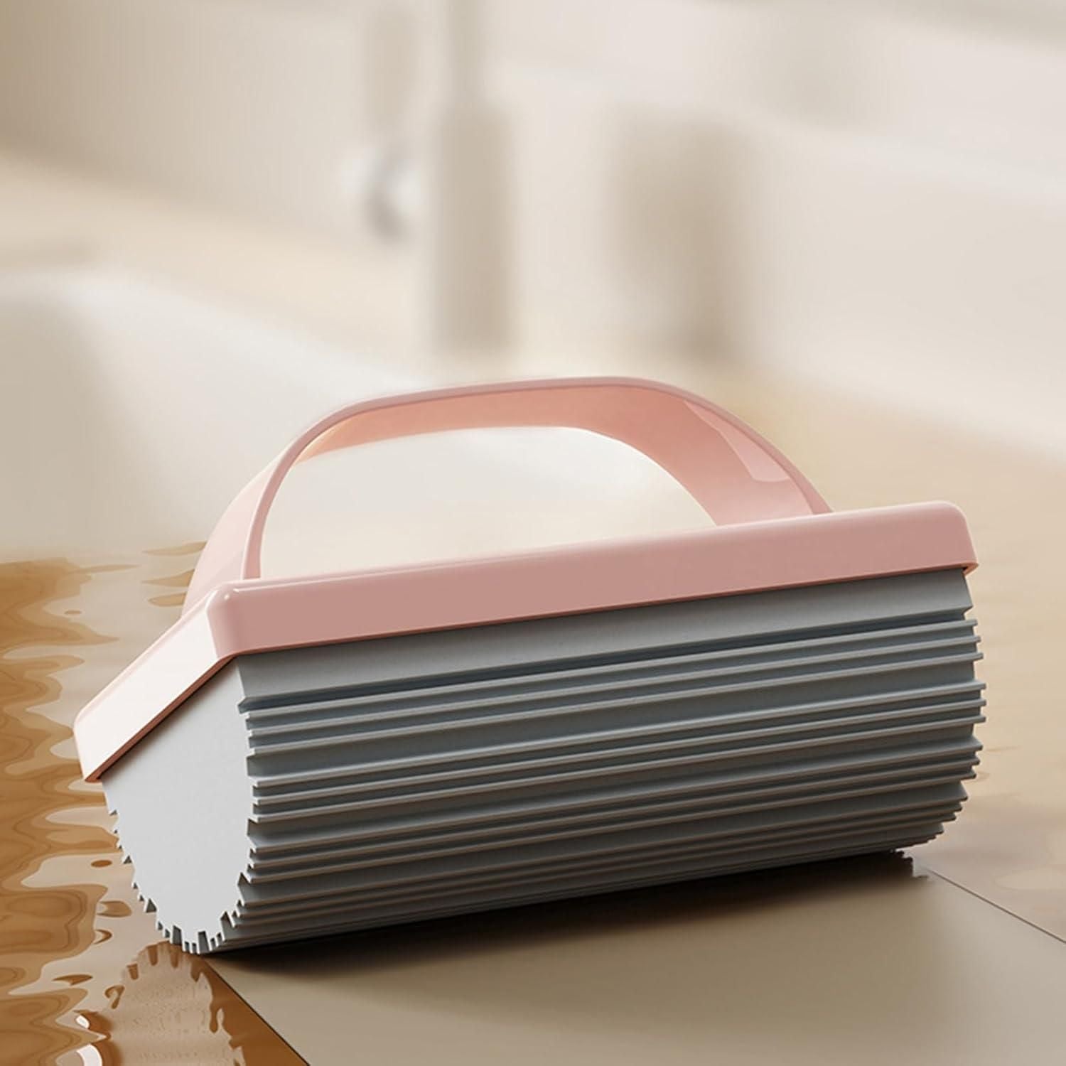 THE GIR FARMER pink handled reusable scrubber for kitchen silicone roller with ridged surface on wet countertop