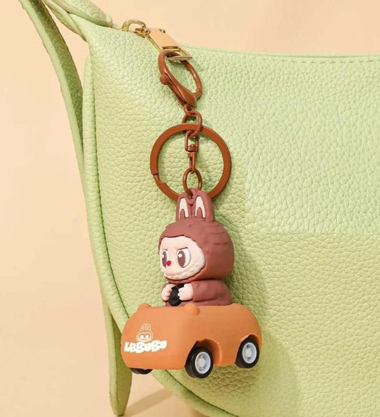 Labubu car keychain featuring a cute character in a brown outfit driving a small orange car