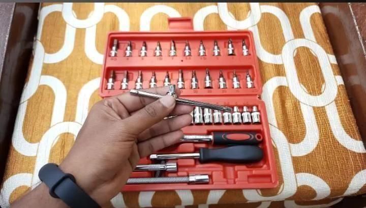 Large all-in-one repair toolkit with various screwdriver bits and a red carrying case held in hand
