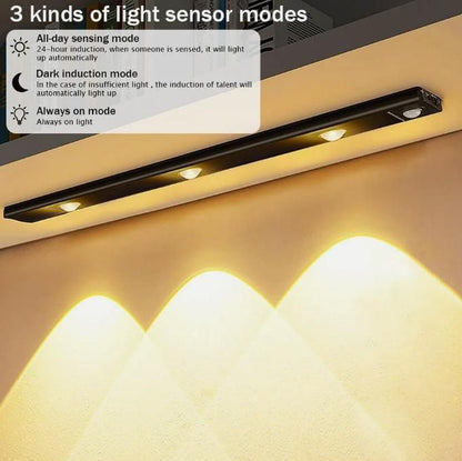 Black LED motion sensor cabinet light with three sensor modes illuminating a wall with warm light