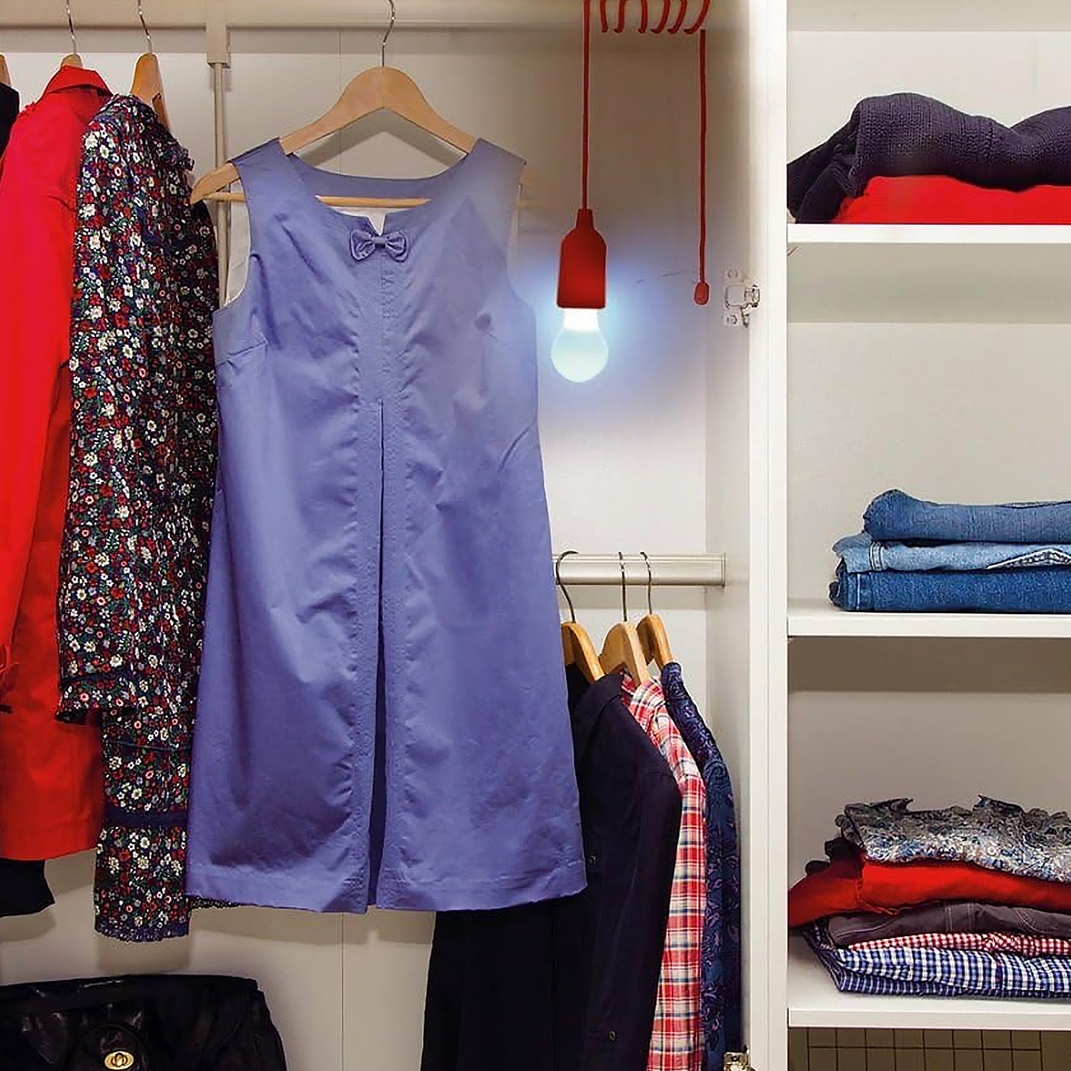 LED pull cord light bulb illuminating a purple dress in a stylish closet